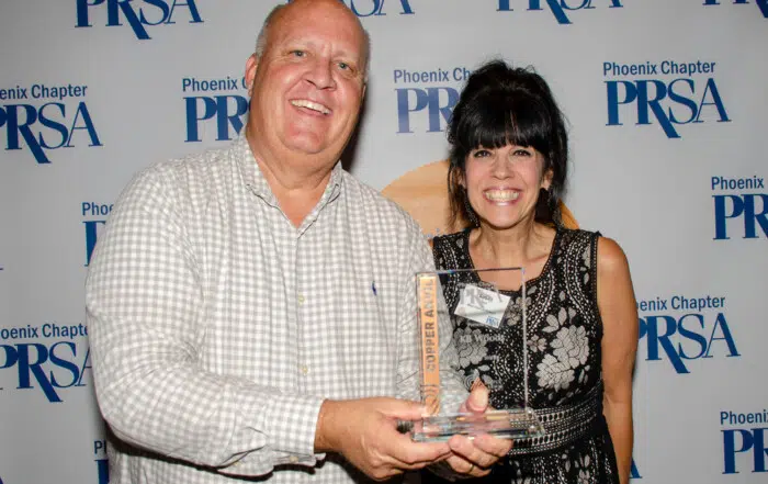 Keith Woods & Susan Ricci posing with an award at the PRSA Copper Anvil Awards 2023